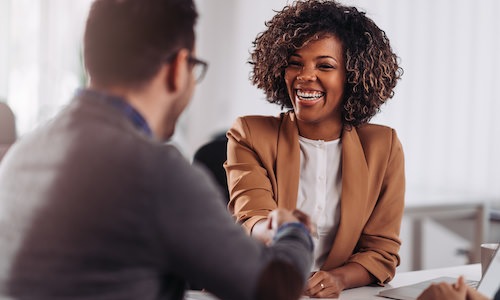 business woman smiling and man shaking hands